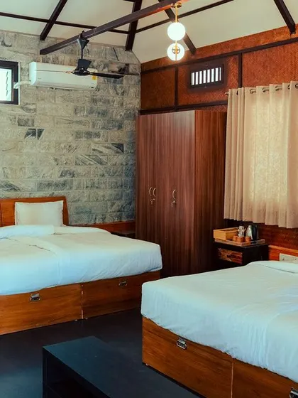 This spacious room at Nandi Hills is perfect for groups, with multiple beds and a design that combines rustic stone walls with modern comforts.