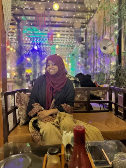 A photo of me at a cafe, a moment of peace. My art has given me the freedom to enjoy these small moments, and I want the same for you.