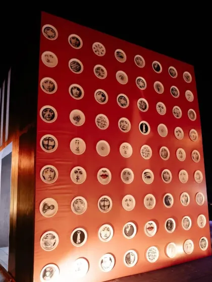 A wall decorated with plates featuring surrealist faces, another nod to the artistic theme. We use these details to create layers of interest and conversation points throughout the venue.