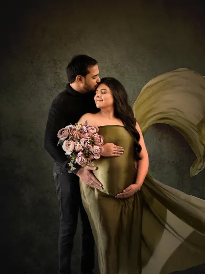 An elegant couple's portrait featuring an olive green fabric drape that adds drama and sophistication.