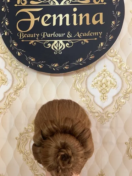 A clean and perfectly executed rose bun, shown on a mannequin head for clarity. This is a fundamental updo style.