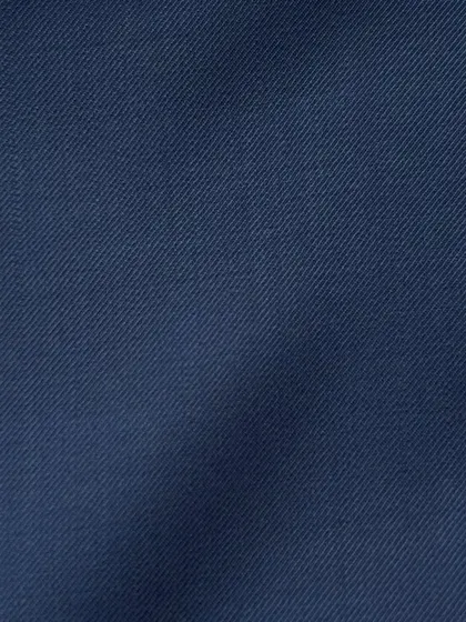 The smooth surface of a navy wool twill, a fabric known for its durability and classic appeal.