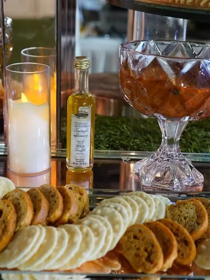A selection of dips and crackers from our grazing table. We use elegant crystal bowls and silver trays to present items like pesto, tomato chutney, and assorted crisps, ensuring every detail is perfect.