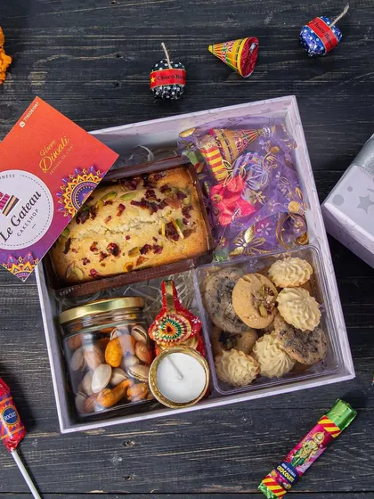 Our Diwali Indulgence Hamper is a step up, featuring a tea cake, dry fruits, gourmet cookies, cracker chocolates, and a handcrafted diya. It's a complete festive package.