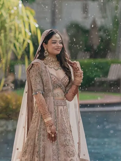 A beautiful portrait of the bride by the pool just before her wedding ceremony in Thailand, with a gentle shower of rain adding a touch of magic.