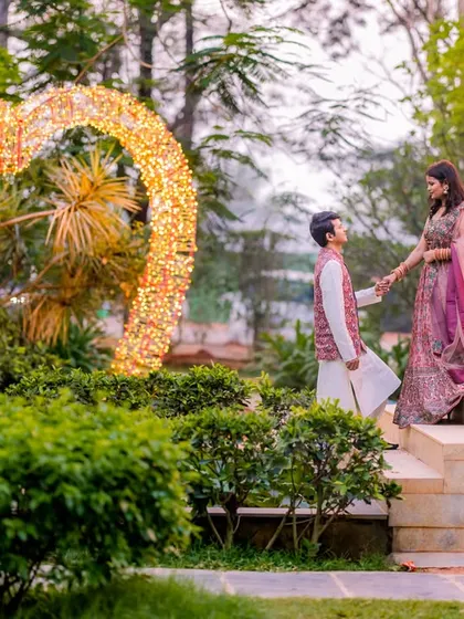 A grand, romantic gesture in front of a heart-shaped light installation. This shot is full of drama and fairy-tale charm.