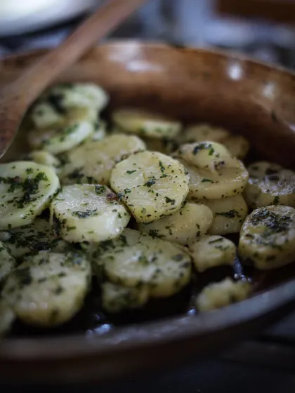 A close-up of herb-tossed potatoes, demonstrating a fundamental cooking technique taught in our course.