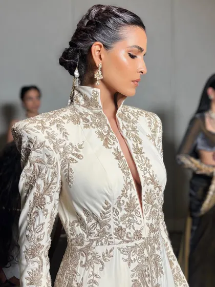 A side profile showcasing the flawless skin and elegant hair styling for the Manish Malhotra show. The makeup is designed to catch the light beautifully as the model walks the runway.