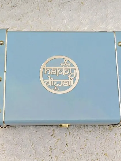 The exterior of one of my custom trunk boxes. This one features a beautiful light blue finish with a 'Happy Diwali' emblem, showcasing how I can tailor the packaging to the occasion.