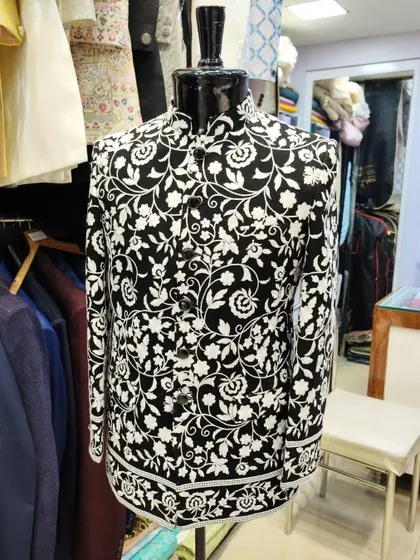 Inspired by celebrity style, this black Jodhpuri jacket features a bold white floral print. It's a modern, high-fashion piece for any wedding event.