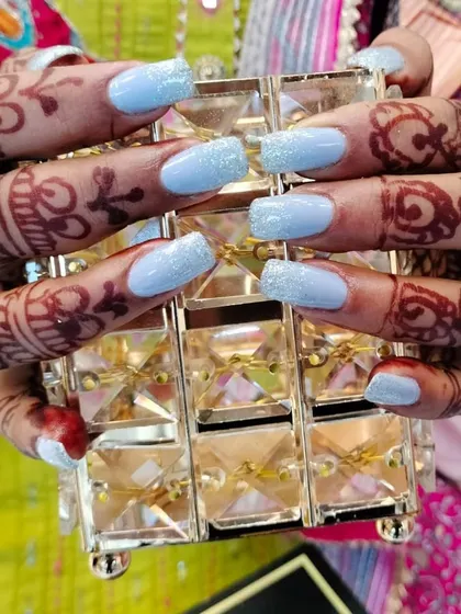 This client was ready for a celebration with her fresh set of light blue glitter nails. These square-shaped extensions look beautiful next to her intricate henna design, showing how I can create the perfect nails for any festive or bridal occasion.
