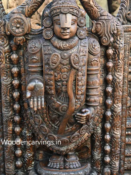 Another view of the Lord Venkatajalapathy statue, focusing on the ornate jewelry and garments carved into the wood.