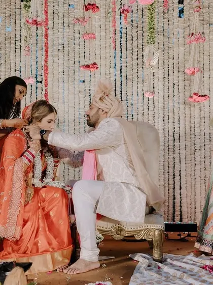 A moment from a cross-cultural wedding ceremony, where family members from both sides participate in the traditional Indian rituals.
