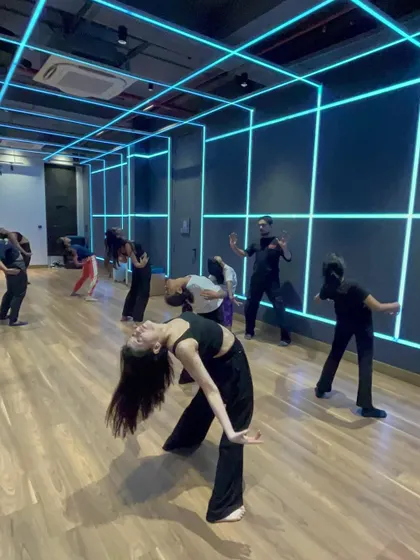 A group of students in my contemporary class practicing a fluid backbend movement in our neon-lit studio.