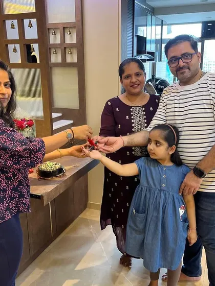 The joy of a new beginning. This photo captures the excitement of a family receiving the keys to their newly designed home, complete with a custom-built console and pooja space.