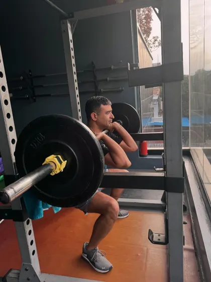 Deep in a front squat, a fundamental exercise for building quadriceps and core strength. The squat rack provides a safe environment for our clients to push their limits.