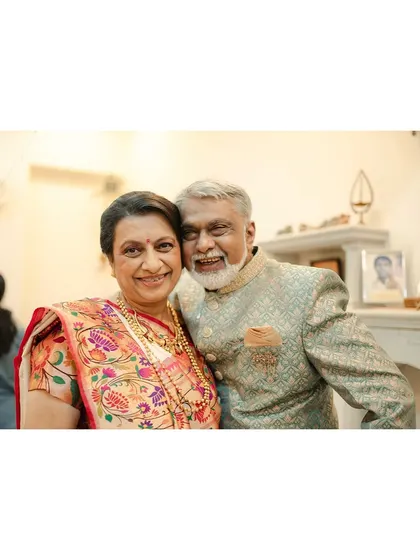 A heartwarming portrait of the groom's parents, dressed in their traditional best for their son's multicultural wedding.