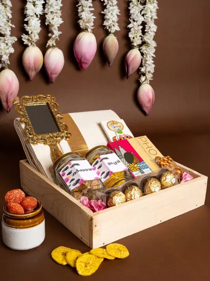 A beautifully styled shot of the 'Pichi Poo' hamper under a cascade of lotus flowers, enhancing the feeling of tradition and natural beauty.