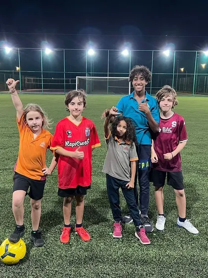 Our academy is a welcoming place for everyone, including expat families looking to connect. This group of players from different backgrounds celebrates after a great training session, showcasing the friendships built on the football pitch.