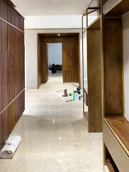 A work-in-progress shot of the stained pine wood paneling and brass-trimmed shelving for a Gurgaon residence. This image captures the project mid-installation, showing the raw materials and craftsmanship before the final finishing touches.