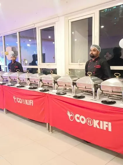 Our team stands ready at a long buffet table for a birthday party at Sobha Dream Acres. The clean, organized setup reflects our professional standards.