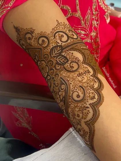 A beautiful Pakistani bridal design for Anam, featuring intricate swirls and floral motifs on the forearm.