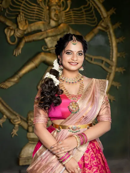 A stunning look for a pre-wedding event. The bride is wearing a beautiful pink langa davani, and her makeup is kept fresh and radiant with a traditional touch.
