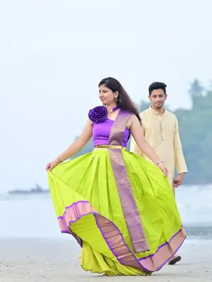The flowy lime green skirt of the lehenga is perfect for a beach setting, adding movement and a playful touch to the couple's pre-wedding photos.