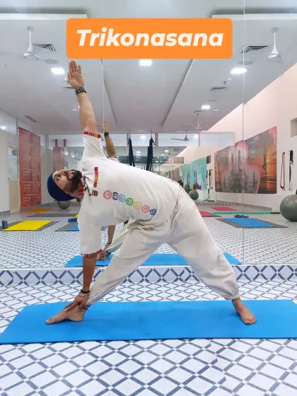 Here I am in Trikonasana (Triangle Pose). This fundamental standing pose stretches the hips, spine, and legs while strengthening the core and improving balance.