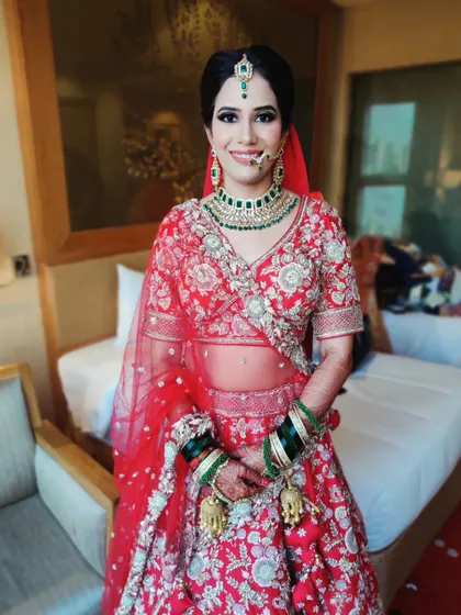 A happy, smiling portrait of the bride in her room before the ceremony. The makeup is fresh and flawless, ready for the big day ahead.