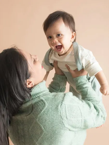 A mother lifts her son into the air, and his face is pure joy. This is the kind of energetic, happy moment I love to freeze in time.