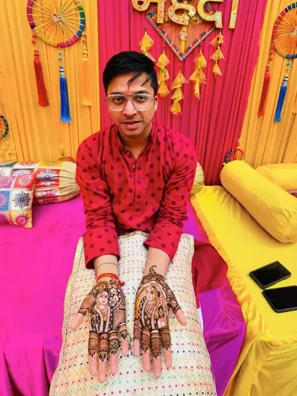 A wider view of the groom's portrait mehandi, showing how the designs are placed symmetrically on both palms for a balanced and striking look.