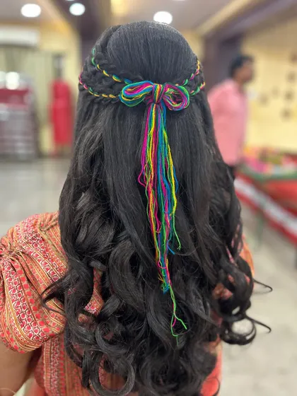 The back view of this creative Mehendi hairstyle, finished with a cute bow made from the colorful threads.