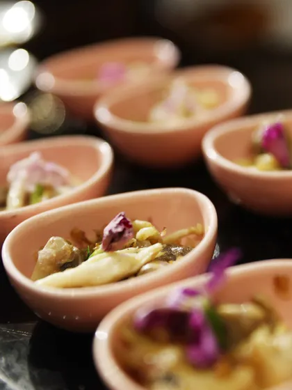 A close-up of our small-bite canapés, served in delicate pink bowls and garnished with edible flowers. Every detail is considered to create a luxurious and poetic dining experience.