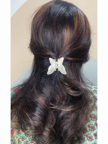 A simple half-up style with a butterfly clip, showcasing how great highlights look even in a casual, everyday hairstyle.
