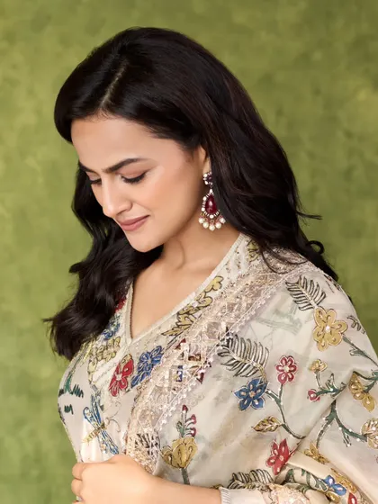 A close-up of Shraddha Srinath in a beautiful floral printed saree. The intricate embroidery and ruby earrings add a touch of vintage charm.