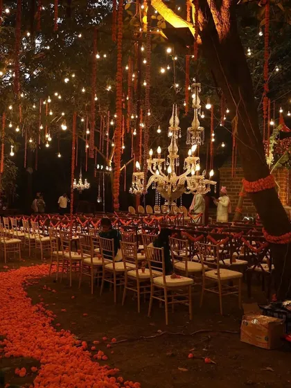 Ambiance is everything, especially after the sun goes down. I transformed this outdoor space into an enchanted forest with strings of marigolds, hanging bulbs, and elegant chandeliers, creating a warm and magical setting for an evening ceremony.