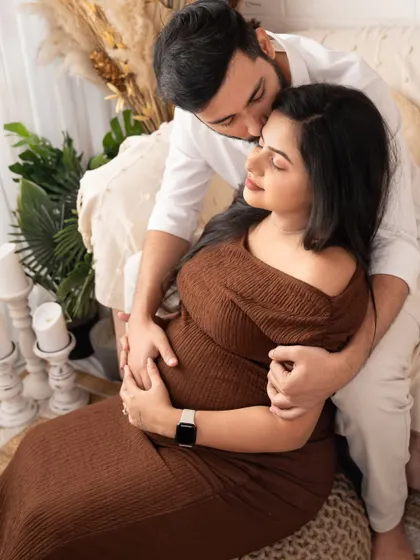 A sweet kiss filled with love and promise. This close-up shot captures the intimacy and affection between the expecting parents.