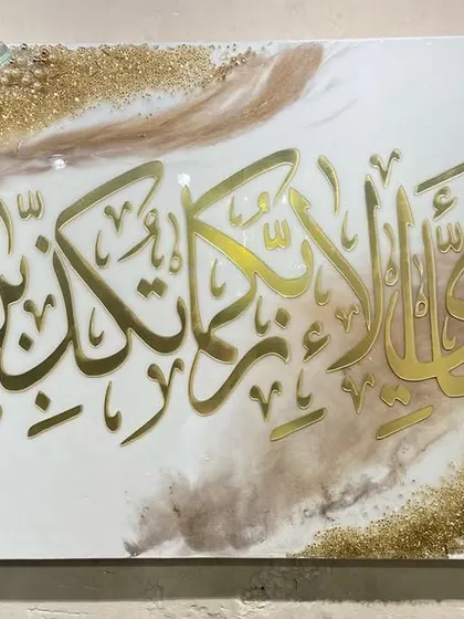 A beautiful reminder of gratitude, this piece features the verse 'Fabi-ayyi ala-i rabbikuma tukaththiban' from Surah Ar-Rahman. The gold calligraphy flows across a white and beige marble-effect resin base, bordered by pearls and crystals.