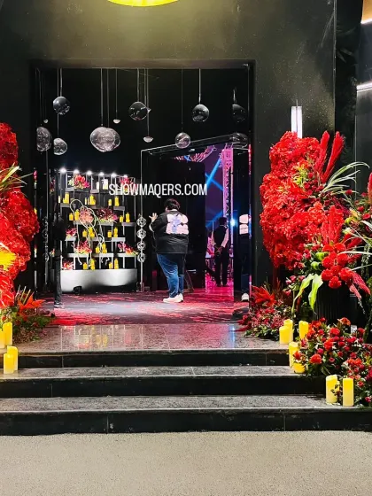 The grand entrance to the red and black themed cocktail party, flanked by massive arrangements of exotic red flowers.