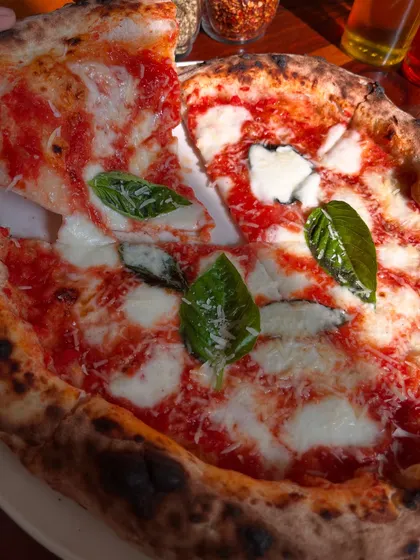 Grabbing the first slice of a fresh Margherita. Look at that cheese stretch!