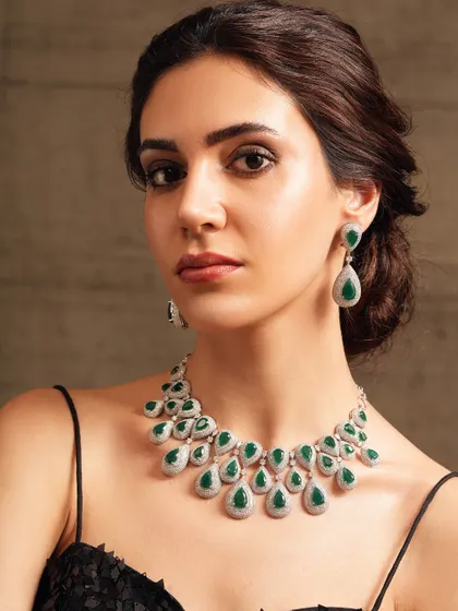 A beautiful necklace with cascading teardrop-shaped emeralds, set in silver-toned metal.