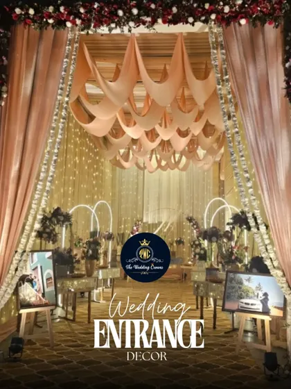 A modern and chic wedding entrance featuring draped fabric, warm lighting, and personalized art on easels. This setup creates an intimate and stylish welcome for guests.