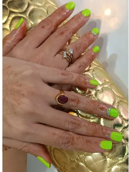 Go bold with this electrifying neon green manicure. Some nails feature a sparkling accent at the cuticle, adding a bit of extra flair to an already show-stopping color choice.