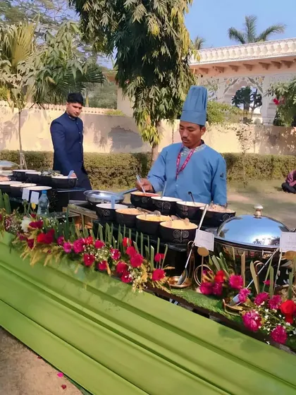 A wide shot of our live food counter at an outdoor event. Our uniformed chefs and well-organized stations ensure efficient service and a professional presentation.