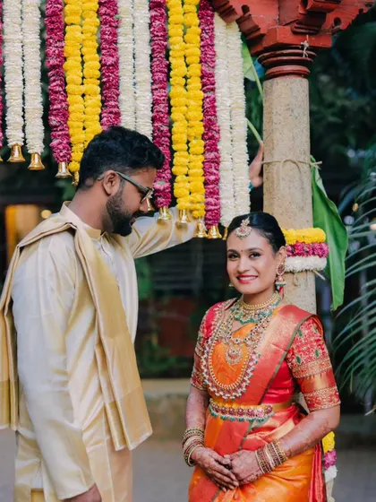 A lovely candid moment between the couple under a canopy of flowers. The groom's admiring glance at his bride says it all.