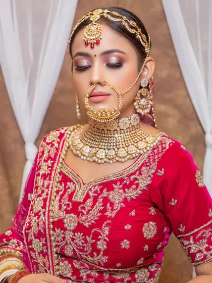 A full bridal set is more than just a necklace. This look features a pearl-drop Kundan choker, matching earrings, a delicate nath, and a sheesh patti, all coordinated to complement her pink bridal attire.