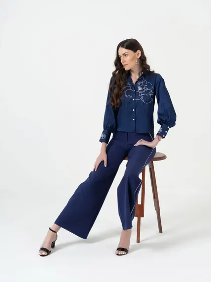 A seated pose for a fashion brand's campaign, showcasing a stylish two-piece outfit. This type of shot is great for social media content and lookbooks.