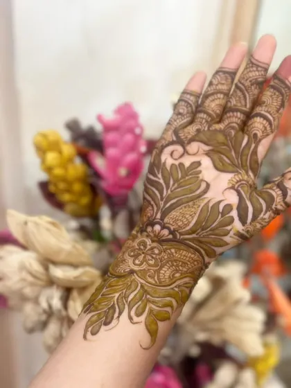 A close-up of a leafy, botanical design that covers the back of the hand and wrist.