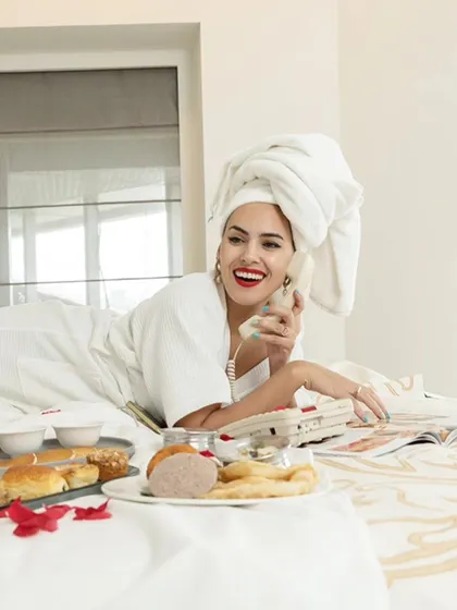 A bright and happy portrait from the hotel bed series. The natural light and the model's smile create a fresh and inviting atmosphere.